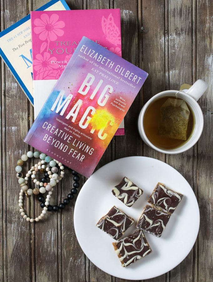 Books, a cup of tea, bracelets, a plate of cookies.