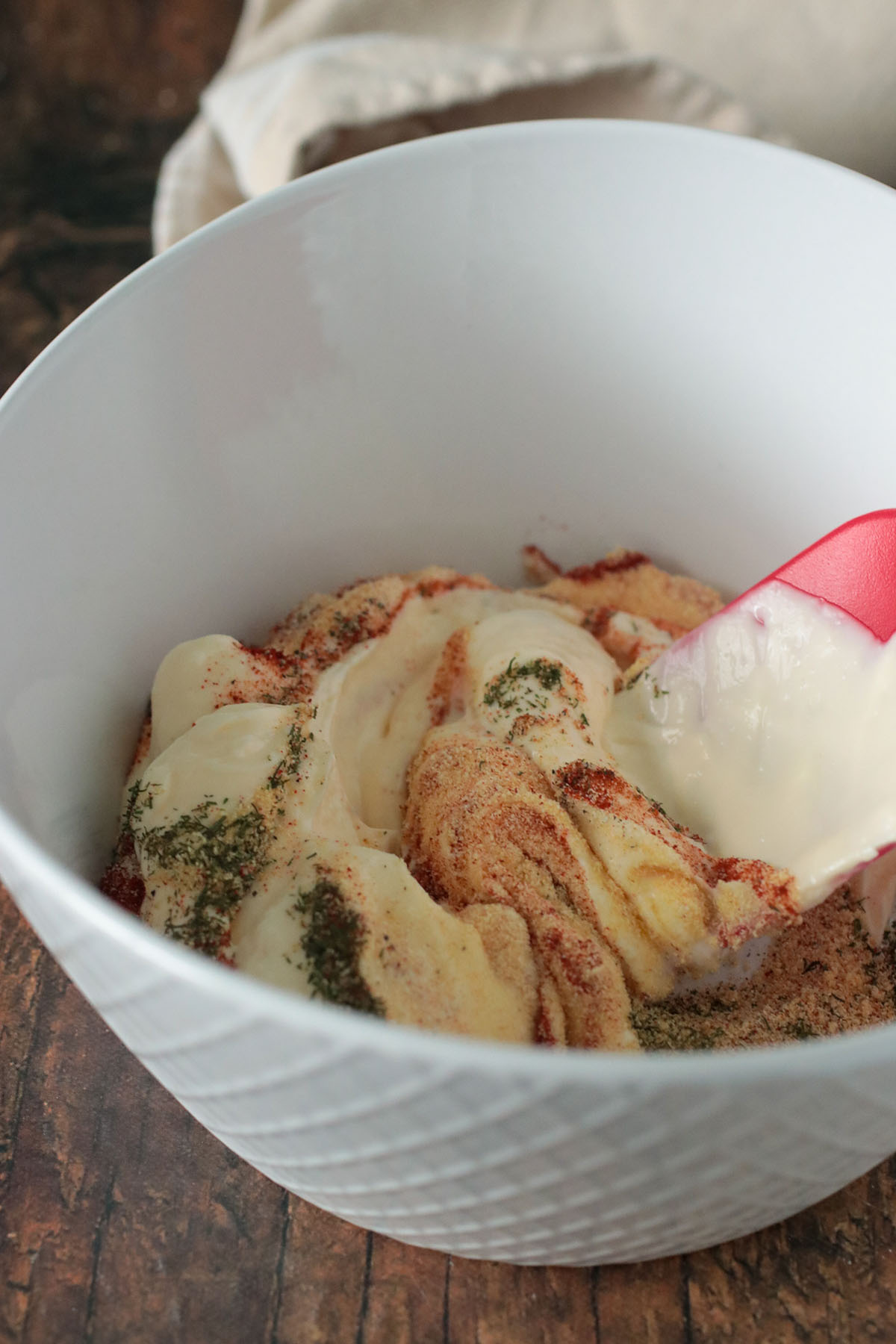 Stirring together the mayo mixture in a bowl.